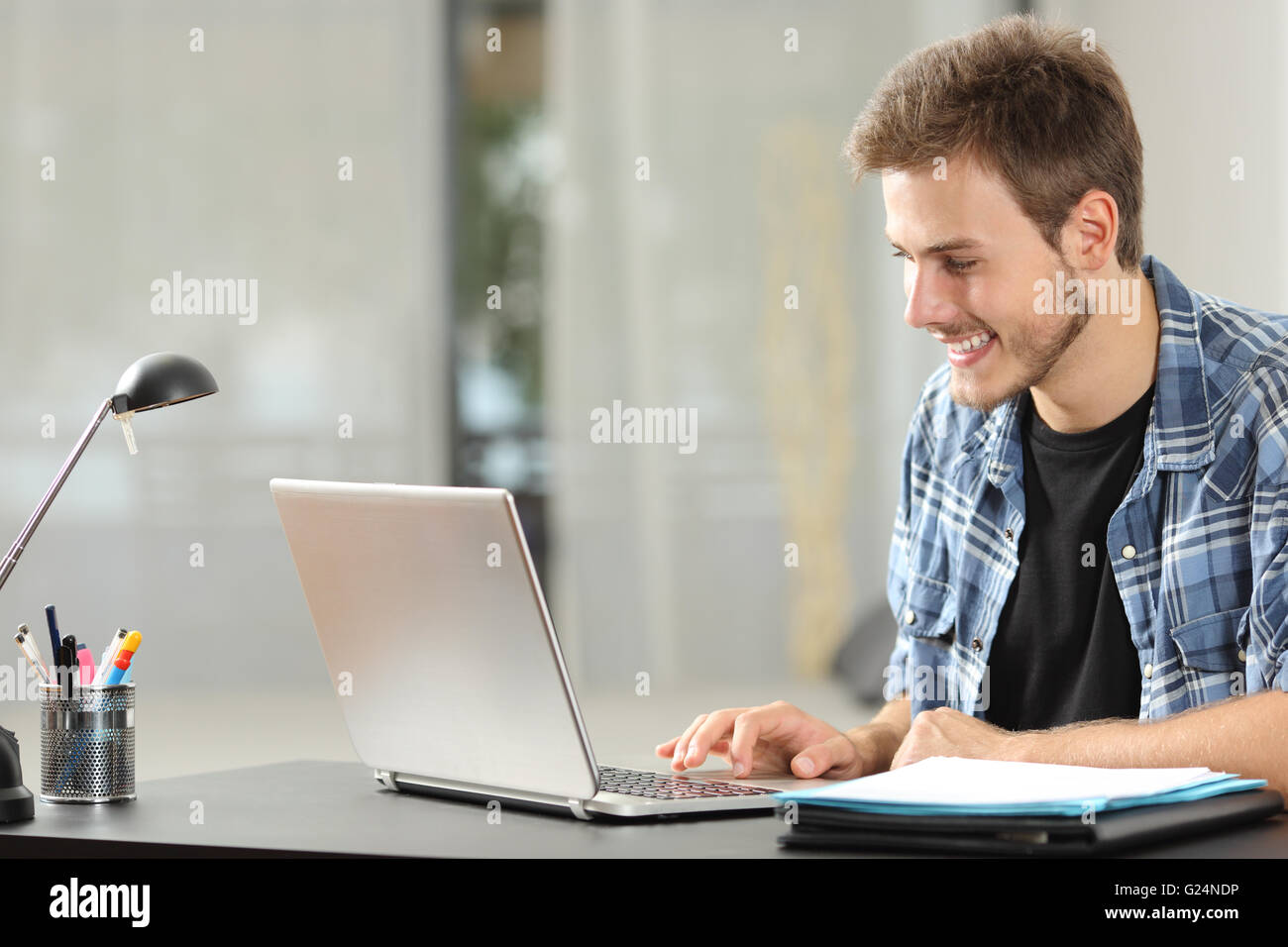 Entrepreneur ou homme d'étudiants qui travaillent ou étudient à l'aide d'un ordinateur portable sur un bureau à la maison Banque D'Images