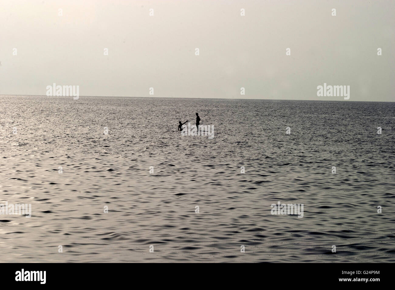 Une belle photo de deux personnes debout sur un rocher au milieu de la mer, surréalistes, rêveur, magique, intemporel, nature Banque D'Images