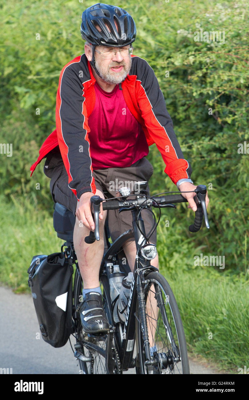 Cycliste homme solitaire dans un top rouge sur le casque d'une dynamo de Dunwich la nuit en vélo de Londres à la côte du Suffolk. Banque D'Images