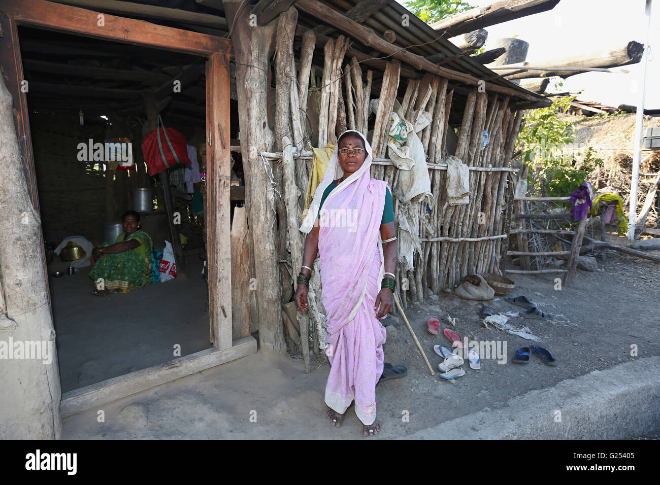 Tribu Gond - vieille femme debout devant sa maison en Shivshaktinagar Ghogarwadi, Maharashtra, en Inde Banque D'Images
