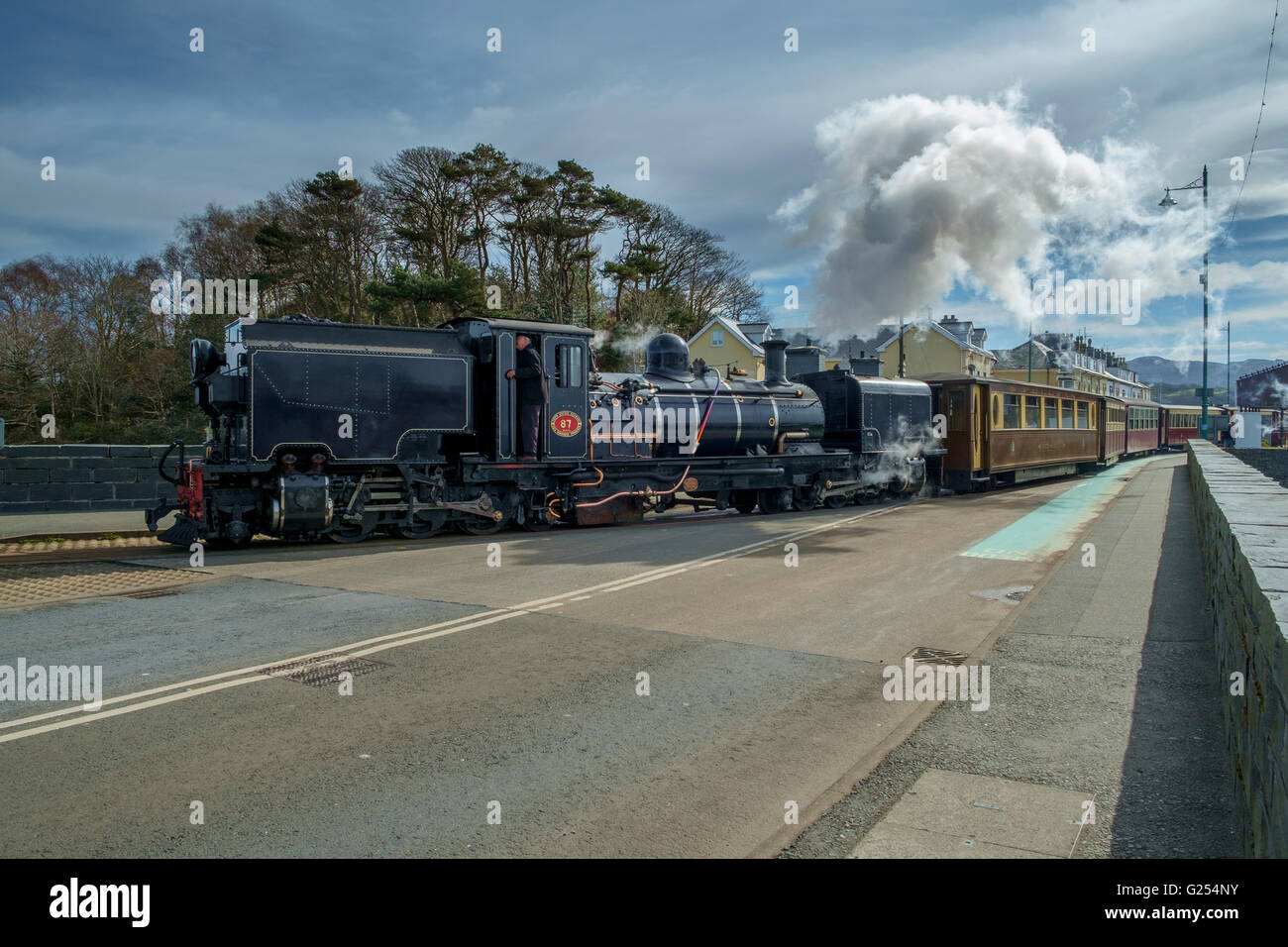 La locomotive à vapeur de la ligne qui traverse la Welsh Highland Road à Porthmadog Gwynedd au Pays de Galles, UKcrossing,train, vapeur, Banque D'Images