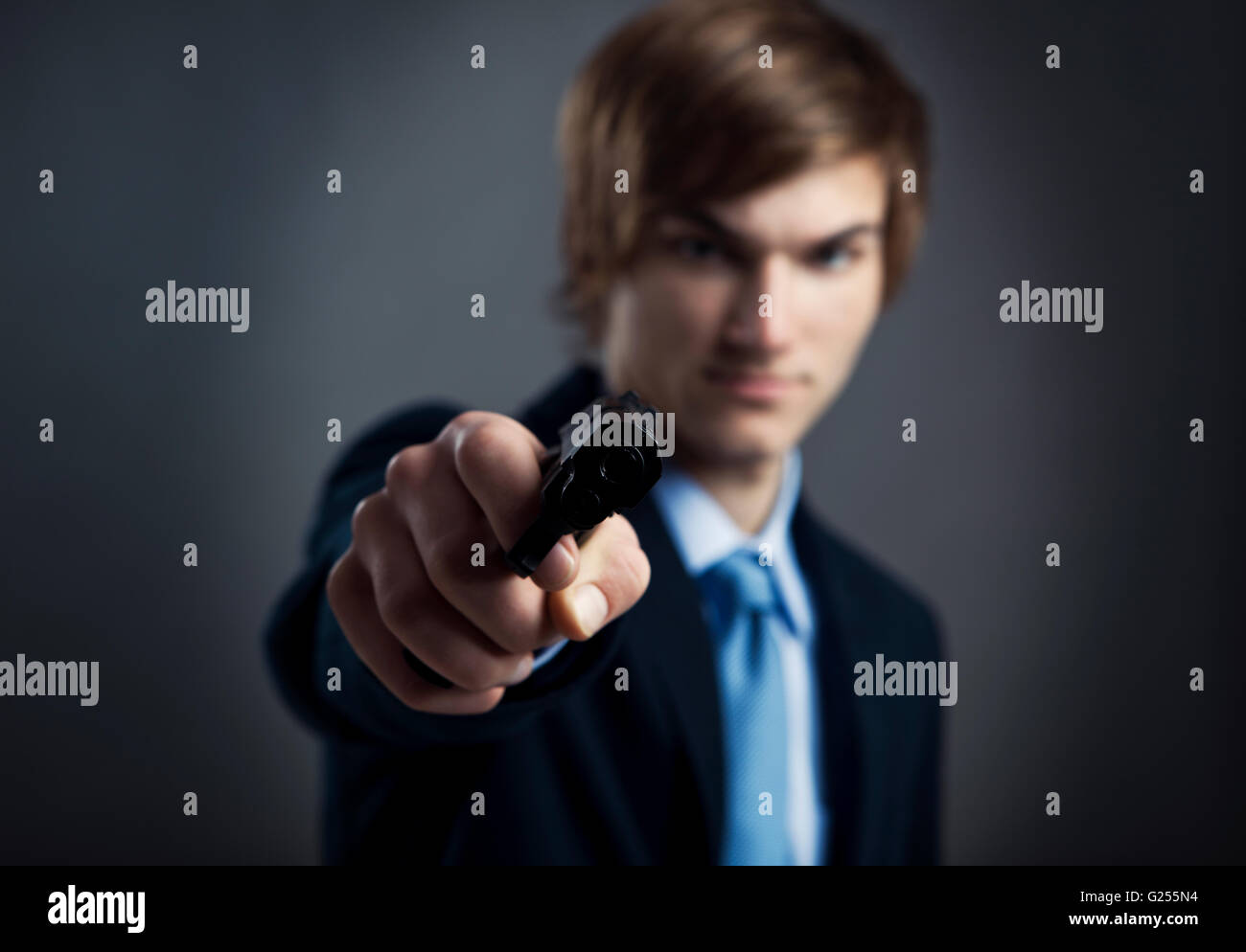 Businessman holding a souligné et en pointant une arme à feu à l'appareil photo Banque D'Images