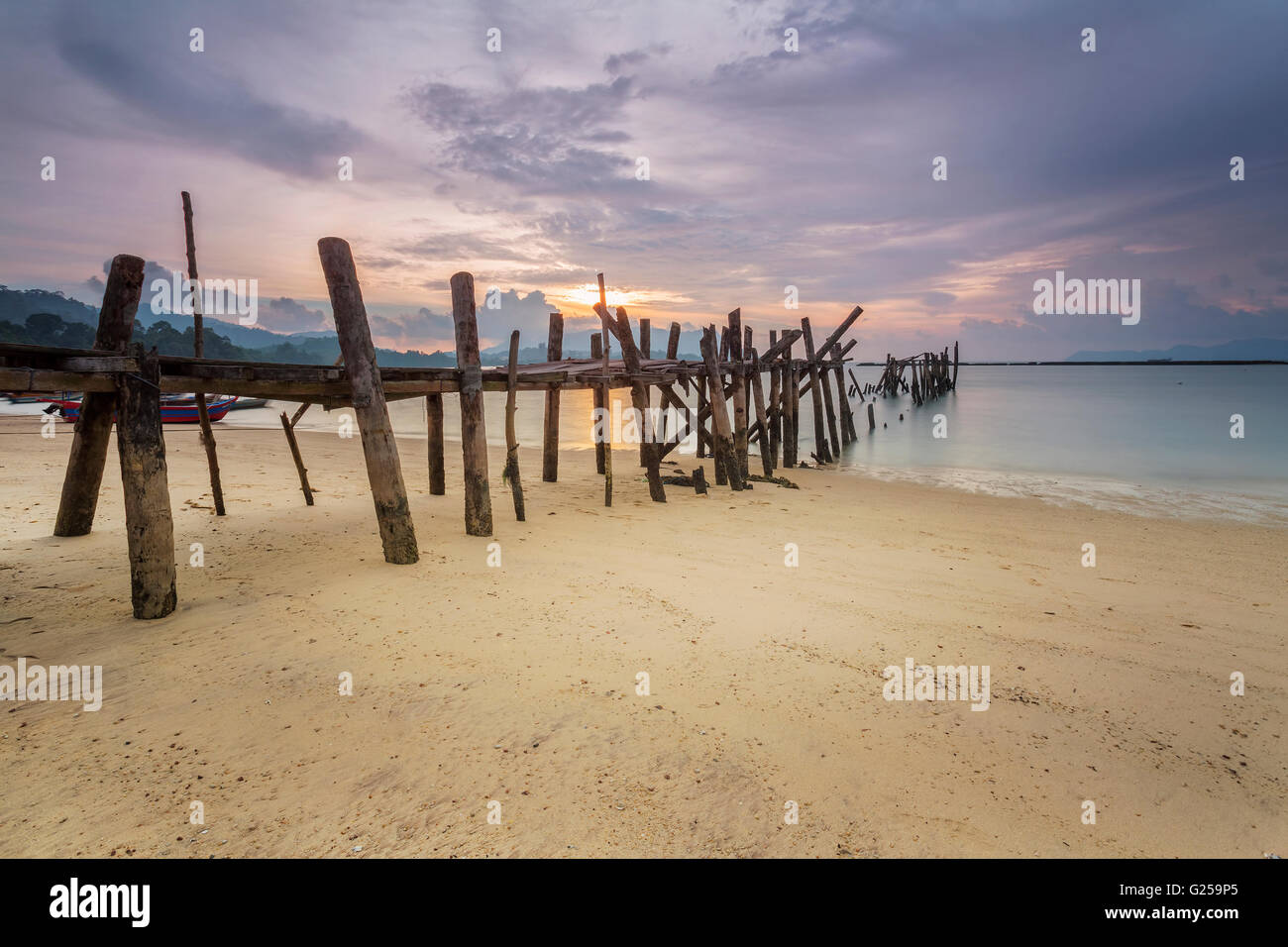 Jetée de plage de sable noir au coucher du soleil, Langkawi, Malaisie Banque D'Images
