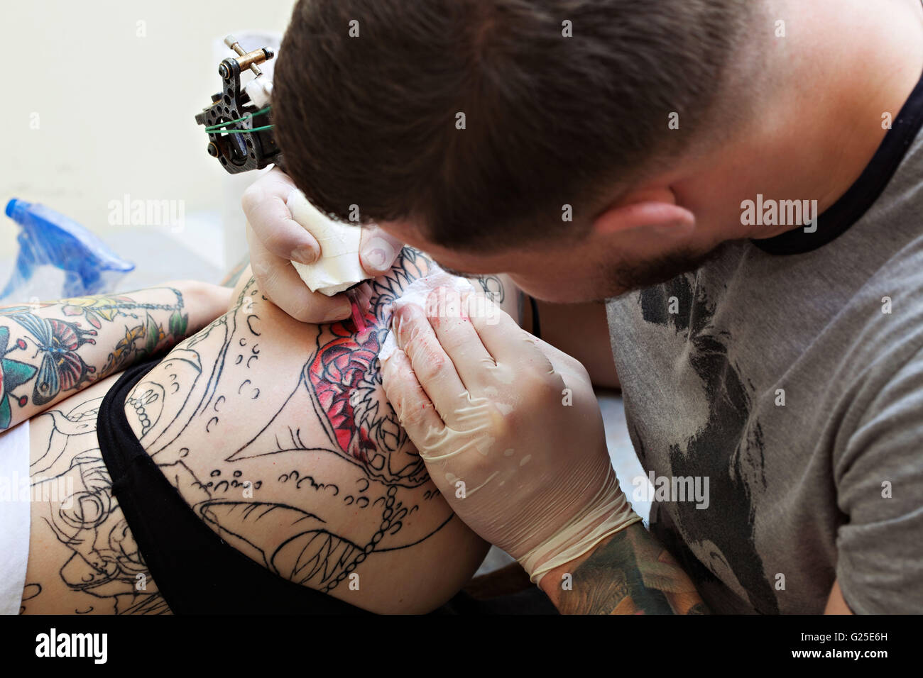 Close-up de tatoueur s'appuie sur la hanche de la jeune fille Banque D'Images