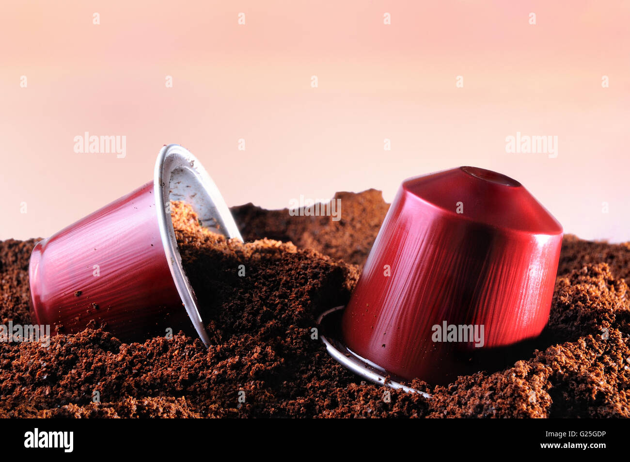 Capsules pour machine à café expresso sur heap de café moulu et marron fond isolé Banque D'Images