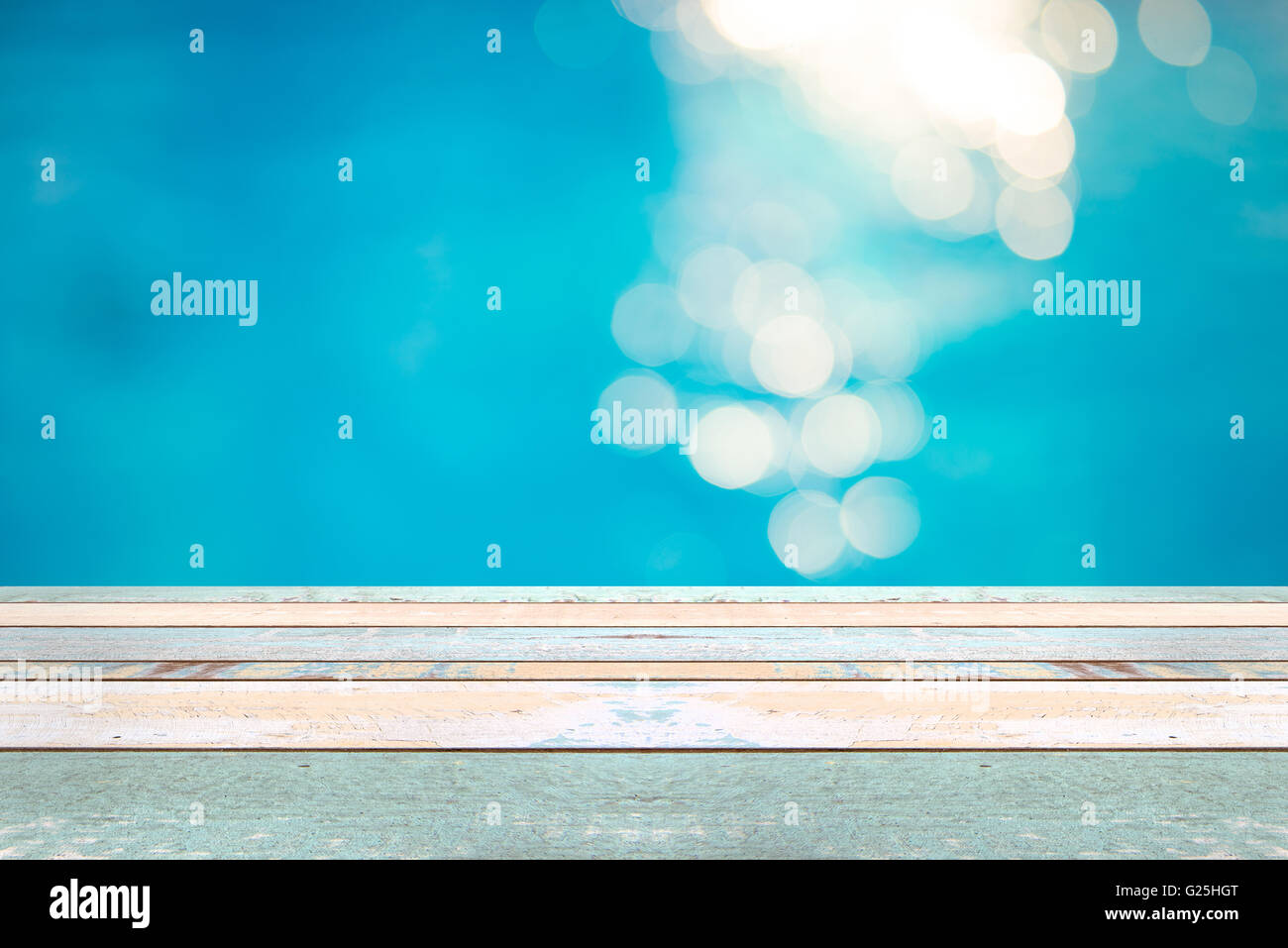 Table en bois vue et Soft focus bokeh effets lumière sur un fond de l'eau ridée, bleu dans la piscine, l'affichage des produits Banque D'Images