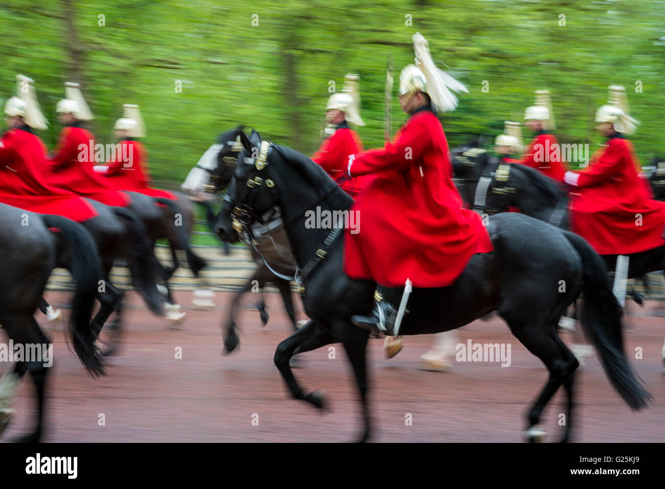La garde royale à cheval habillés en tuniques rouges de cérémonie col dans un défilé sur un jour de pluie sur le Mall à Londres, Angleterre, RU Banque D'Images