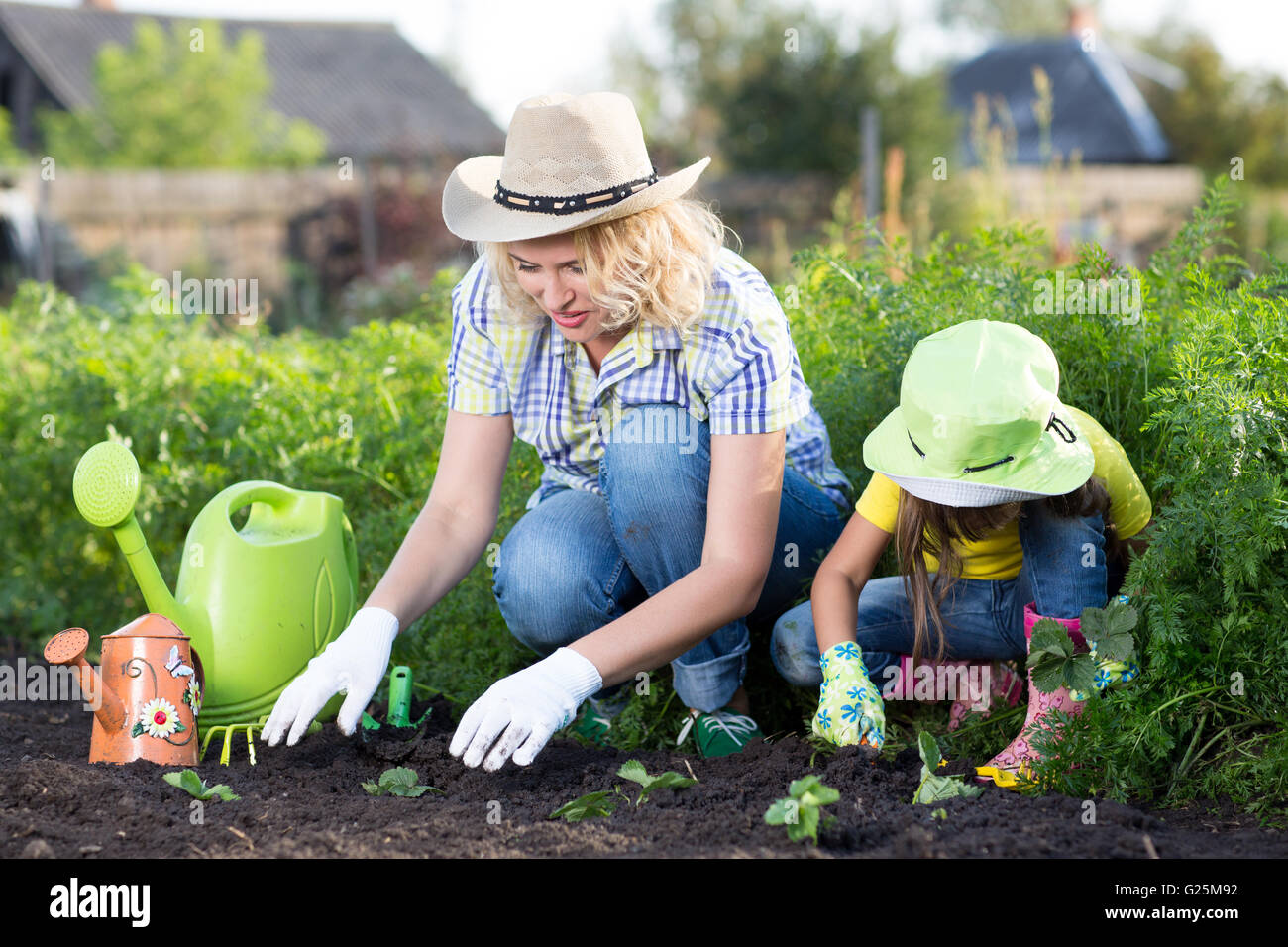 Jardinage, plantation - Mère avec enfant fille fraise en semis de plantes garden bed Banque D'Images