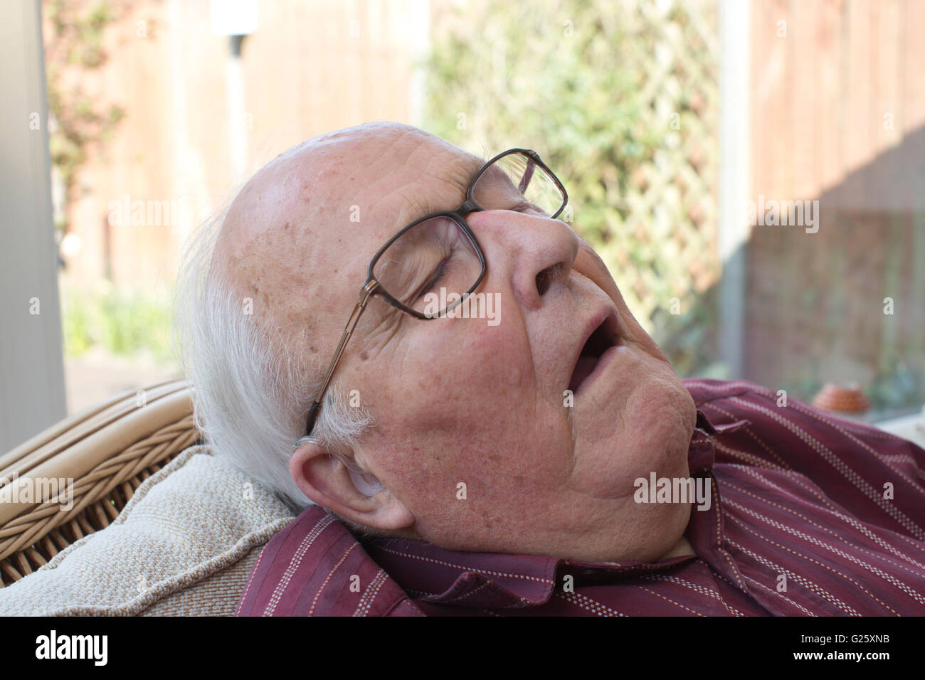 Personnes âgées pensionné prend une sieste à la maison, England, UK Banque D'Images