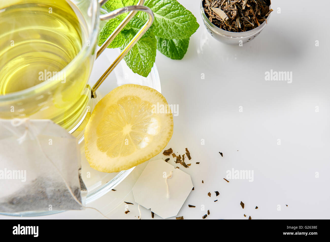 Tasse en verre de thé vert à la Menthe et citron, et sachet de thé sur une table dans le salon de près. Composition horizontale. Vue d'en haut. Banque D'Images