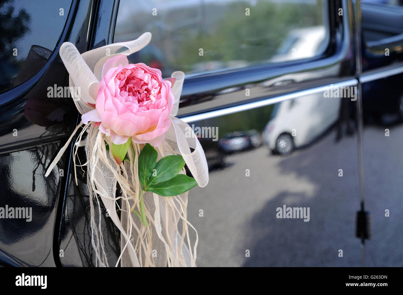 Porte de voiture de mariage noir avec fleur et arc blanc Banque D'Images