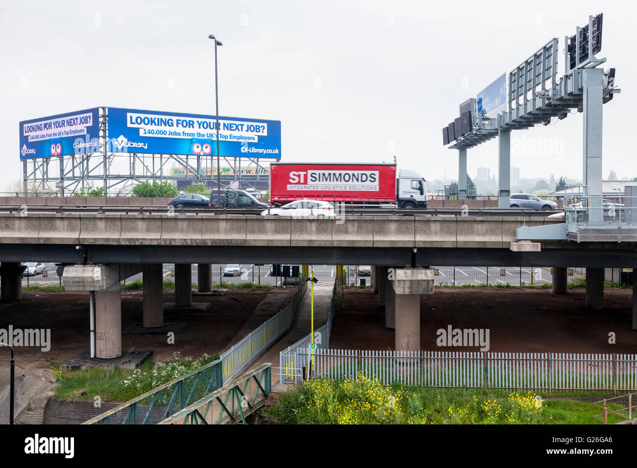 Autoroute M6 avec un panneau routier bras-support et de haut niveau, de panneaux publicitaires électroniques, Walsall Bescot, West Midlands, England, UK Banque D'Images