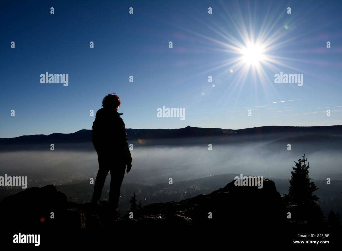 Contour, sombre silhouette du touriste, montagnes de Karkonosze Ridge, soleil et brouillard. Et Sniezne Kotly Szrenica peaks visible. Banque D'Images