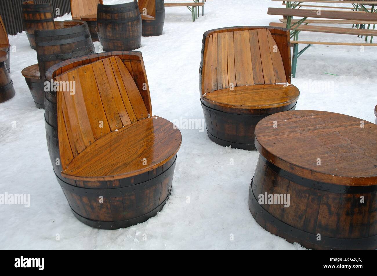 Table en bois et sièges uniques faites de vieux barils debout sur la neige. Banque D'Images