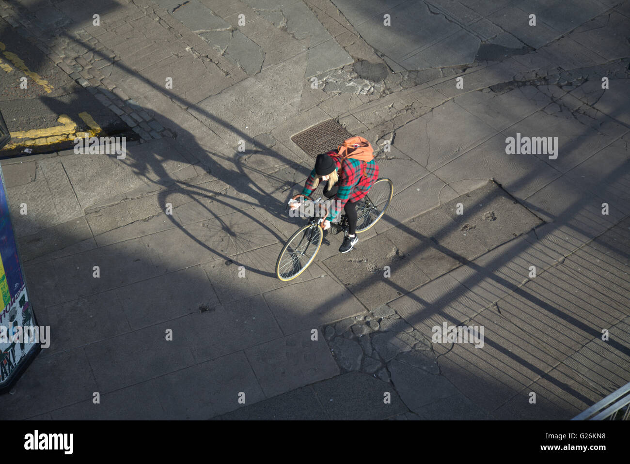 Femme sur un vélo avec des ombres de passage aux feux de circulation (vue de dessus, Glasgow, Ecosse, Royaume-Uni. Banque D'Images
