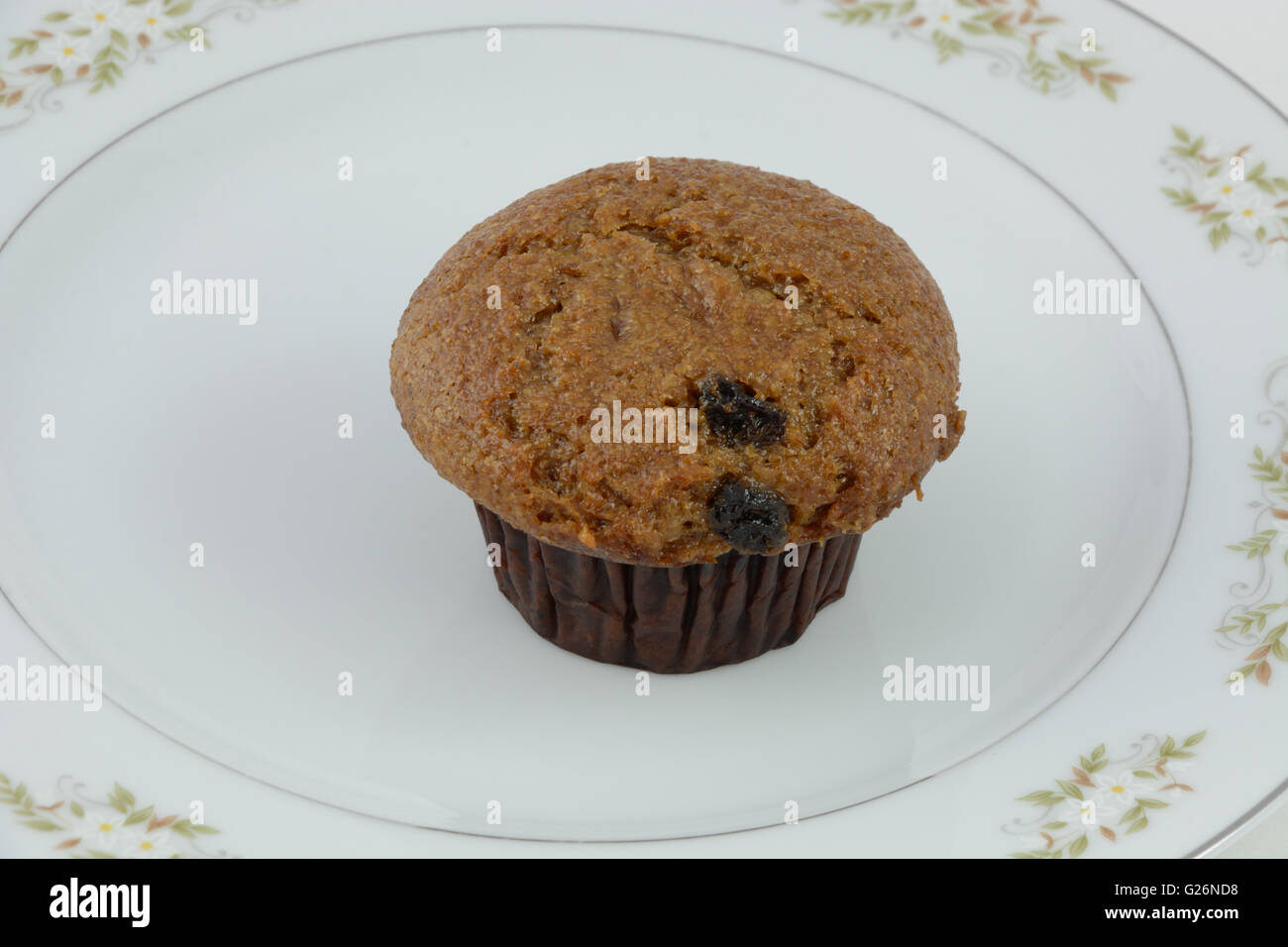 Muffin au son et aux raisins on white plate Banque D'Images