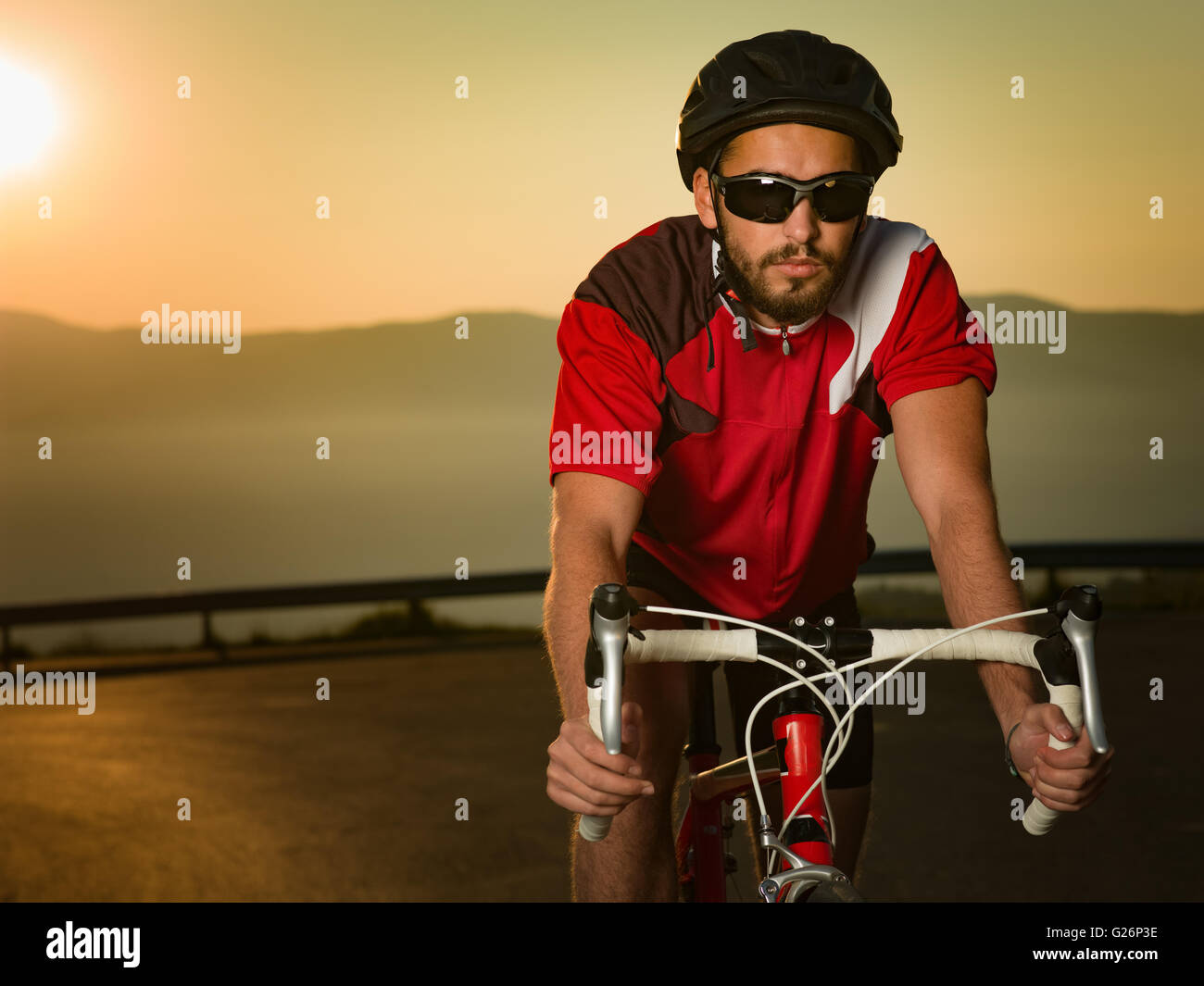 Cycliste sur vélo de route escalade la colline sur une journée ensoleillée Banque D'Images