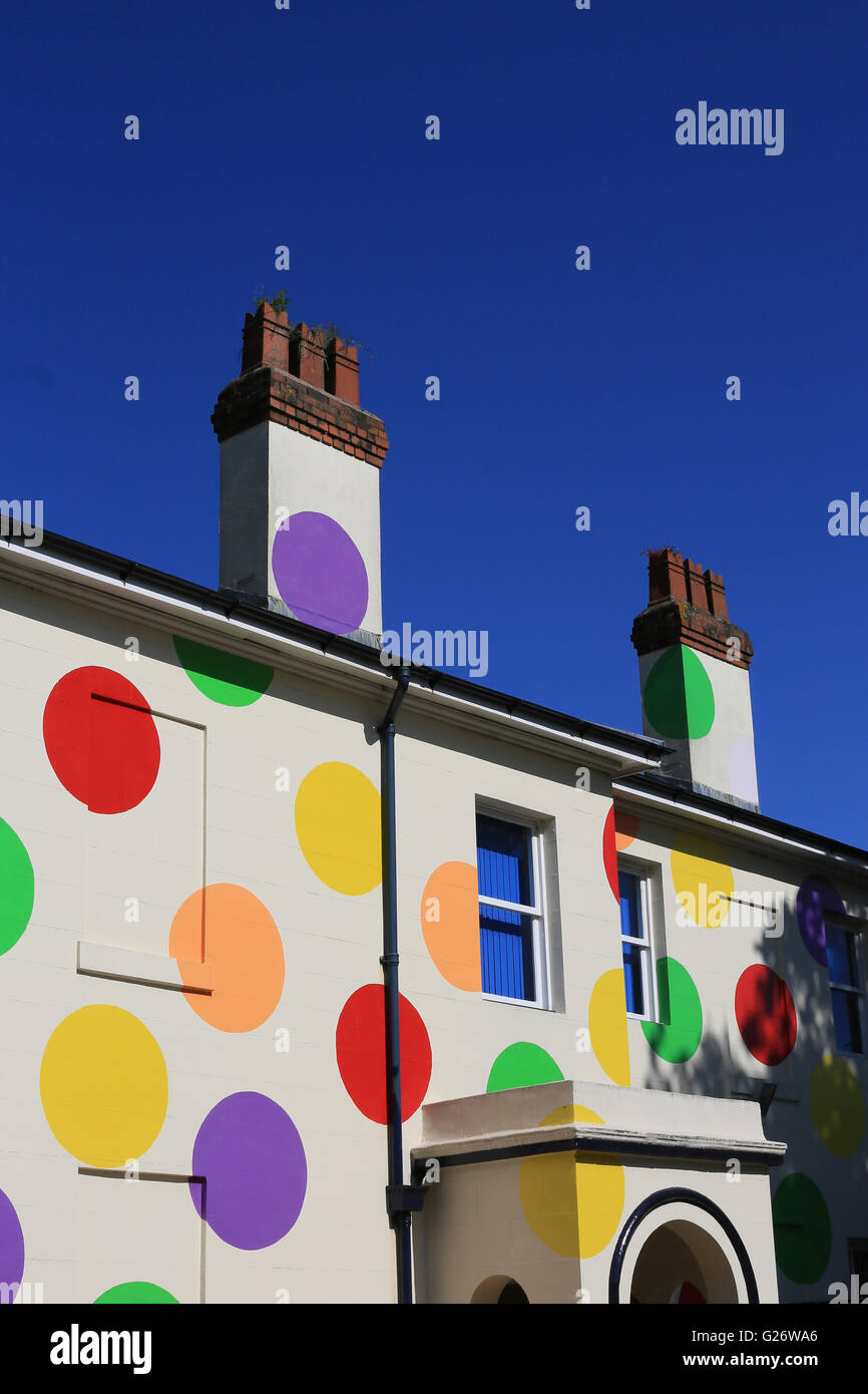 Une grande maison couverte de taches de couleur vive à Walsall, en Angleterre avec un fond de ciel bleu en soleil Banque D'Images