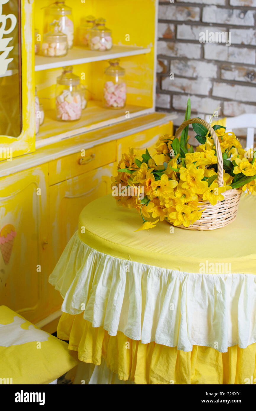 Bouquet de fleurs jaunes dans le panier sur la table dans la cuisine Banque D'Images