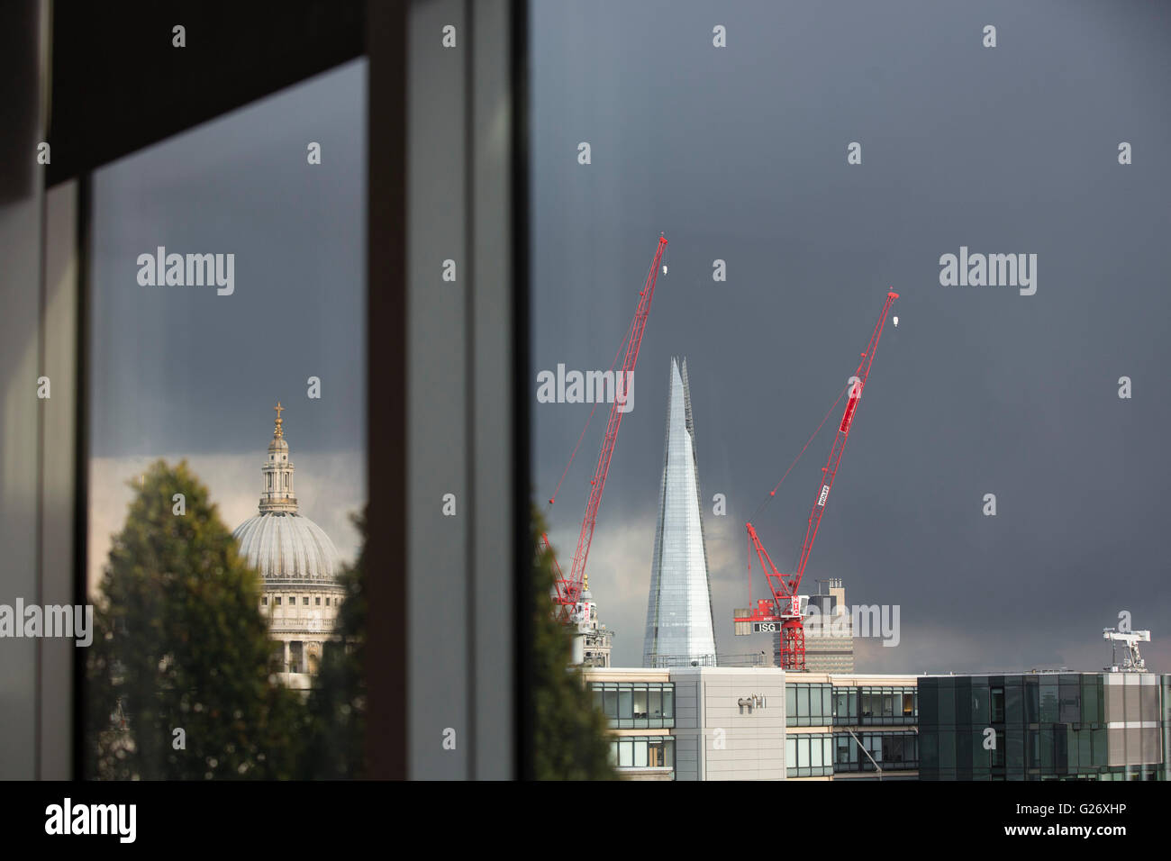 St Pauls Cathderal sur l'horizon avec vue sur les toits de la ville de Londres, et l'arrière de la pyramide de verre comme structure du Shard avec côtés verre brillants dans la lumière et peint rouge evning site construction de grues. Banque D'Images