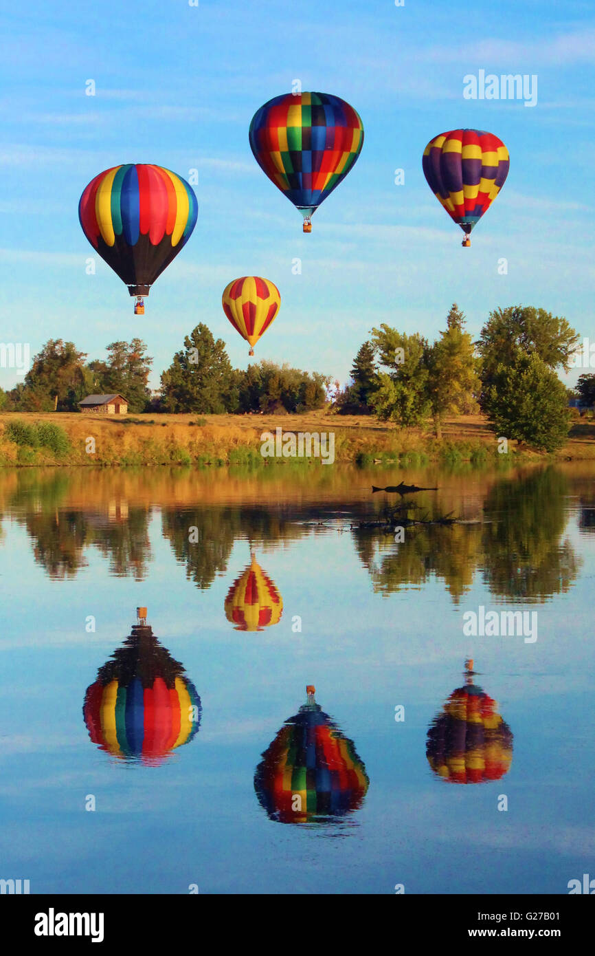 Au cours de l'Prosser, Washington Balloon Rally, hot air balloons pris planant à côté d'une rivière légèrement vallonné sur une belle journée Banque D'Images