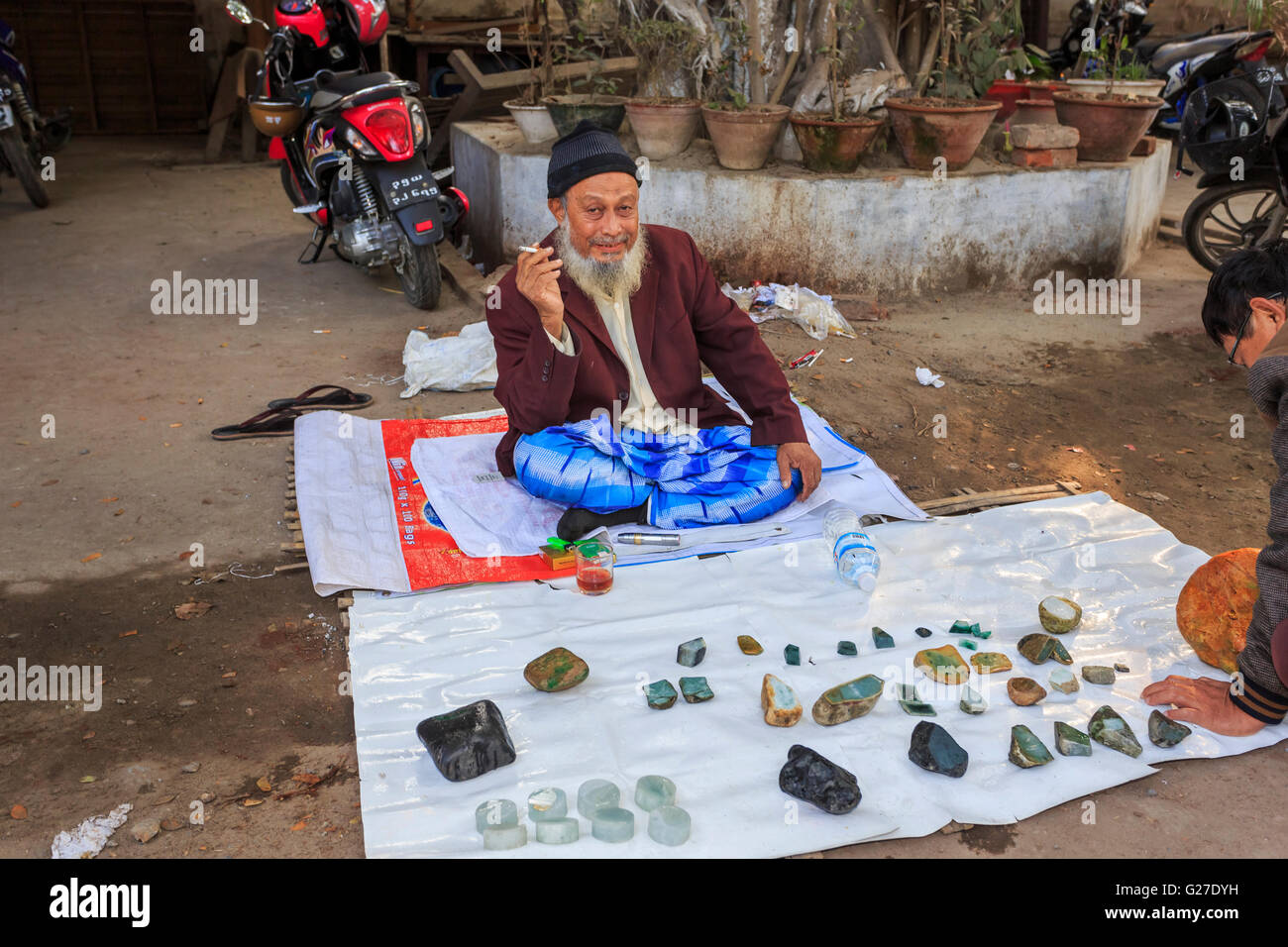 Vendeur barbu avec affichage de couper des morceaux de jade en vente sur le bord de la rue, le marché de Jade, Mandalay, Myanmar (Birmanie) Banque D'Images