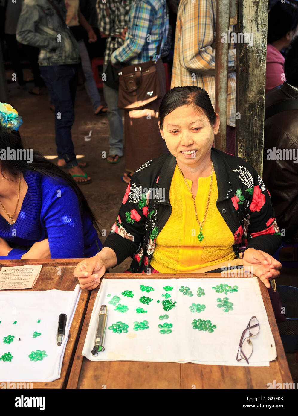Femme locale exposant portant thanaka vente poudre vert jade poli dans le marché de Jade, Mandalay, Myanmar (Birmanie) Banque D'Images