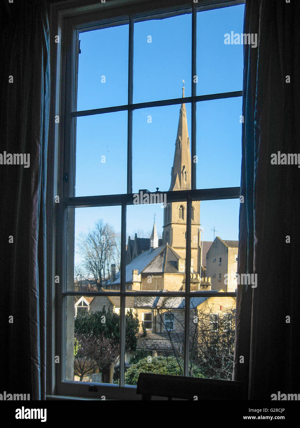St Matthews Church à Bath et maisons en pierre calcaire contre un ciel bleu clair, à travers une fenêtre à guillotine géorgiennes Banque D'Images
