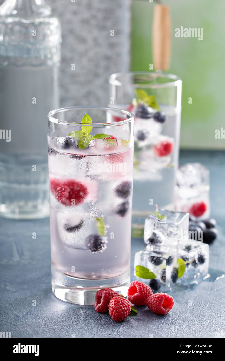 L'eau pétillante avec berry et glace aux herbes Banque D'Images