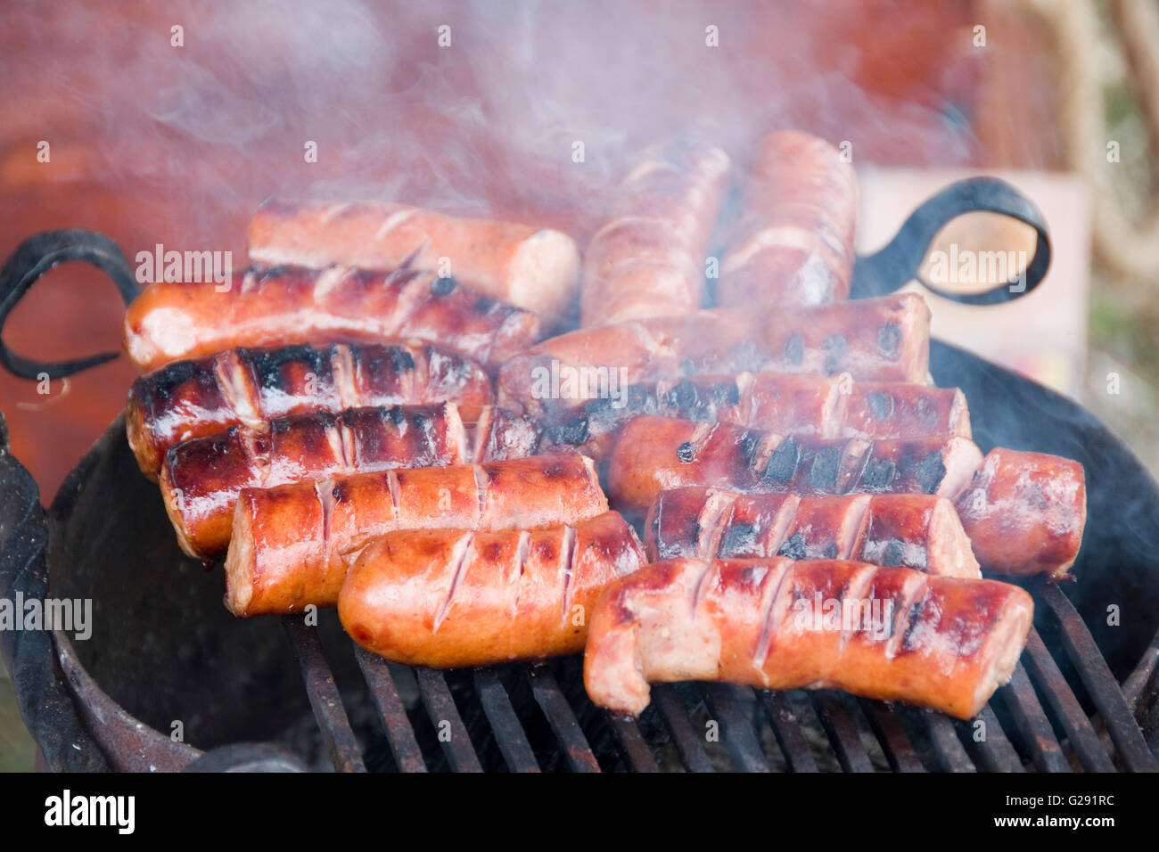 Close up sur les succulentes saucisses allemandes savoureux bratwurst ou cuisson sur un barbecue Banque D'Images