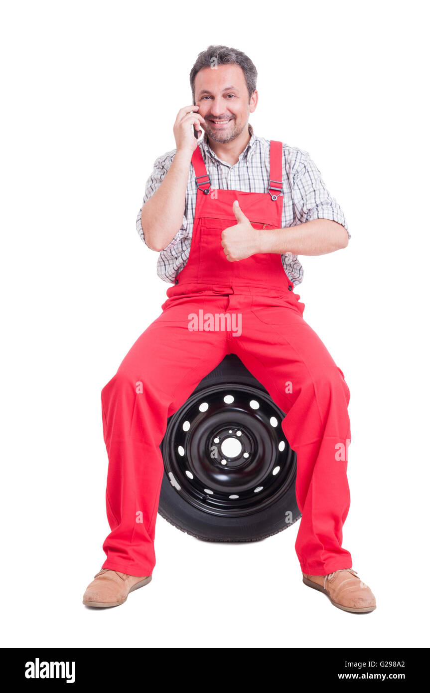 Mécanicien, parlant au téléphone et montrant comme. Contact auto service ou compagnie de vulcanisation des pneus Banque D'Images