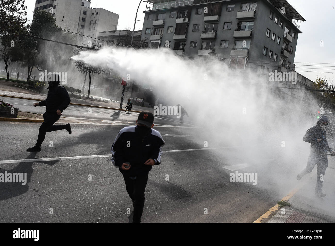 Santiago, Chili. 26 mai, 2016. Un véhicule de la police antiémeutes crache de l'eau contre les manifestants pendant une manifestation à Santiago, capitale du Chili, le 26 mai 2016. La protestation a été appelé par différentes associations étudiantes, demandant la présidente Michelle Bachelet à accélérer le processus de la réforme de l'éducation, selon la presse locale. Credit : Jorge Villegas/Xinhua/Alamy Live News Banque D'Images