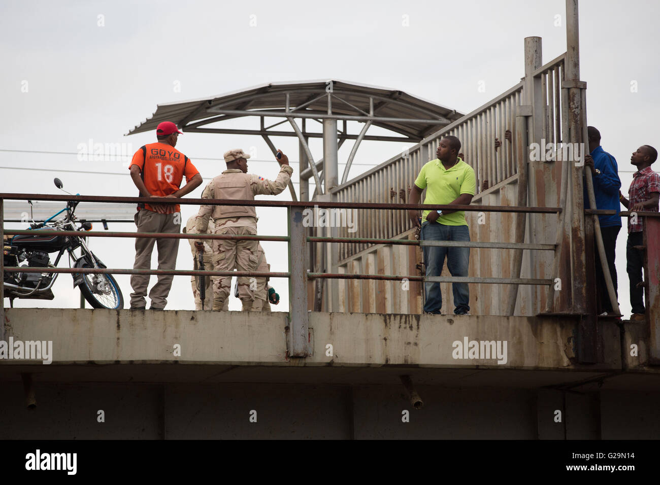 27 mai 2016 - Après avoir escaladé illégalement en provenance d'Haïti, la Police militaire crier et renvoyer cet homme haïtien au cours de la porte ouverte sur le pont à la frontière de la République dominicaine à Dajabon, 27 mai 2016. Beaucoup d'Haïtiens franchir illégalement la frontière chaque lundi et vendredi avant qu'elle ouvre à 8h00 pour vendre leurs marchandises au marché. © Louise Wateridge/ZUMA/Alamy Fil Live News Banque D'Images