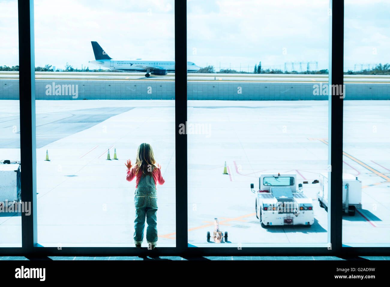 Girl (2-3) à la recherche d'une fenêtre à l'aéroport Banque D'Images