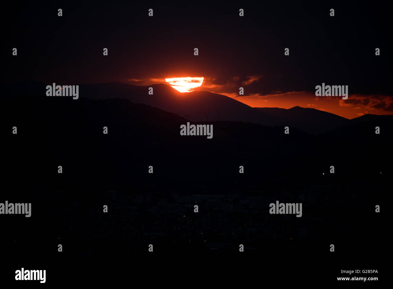 Coucher de soleil sur la chaîne de montagnes Egaleo Athènes Grèce // ATHÈNES, Grèce — Un coucher de soleil rouge spectaculaire illumine la ligne d'horizon ouest d'Athènes. Le soleil se couche derrière la chaîne de montagnes Egaleo, qui forme la frontière ouest de la ville, atteignant une altitude de 468 mètres (1 535 pieds). Les silhouettes des bâtiments dans l'ouest d'Athènes et peut-être des parties du Pirée, situées à environ 12 km (7,5 miles) au sud-ouest du centre d'Athènes, sont visibles contre le ciel éclatant. Cette scène, commune à Athènes en raison de son climat méditerranéen, est intensifiée par les conditions atmosphériques et l'altitude de la ville de 70-300 mètres (230-984 fe Banque D'Images