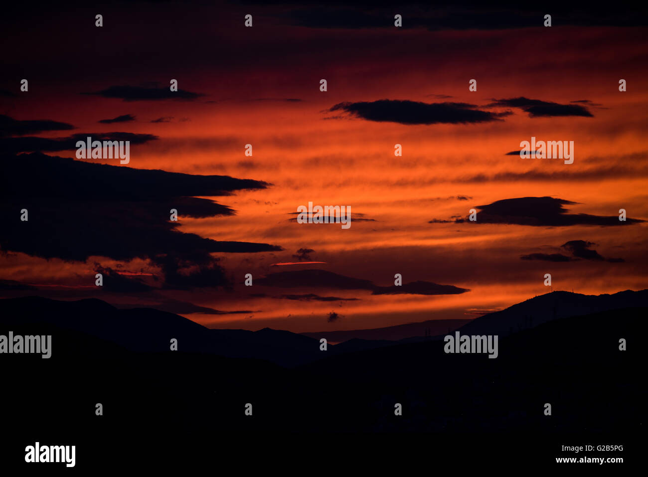 Coucher de soleil sur la chaîne de montagnes Egaleo Athènes Grèce // ATHÈNES, Grèce — Un coucher de soleil rouge spectaculaire illumine la ligne d'horizon ouest d'Athènes. Le soleil se couche derrière la chaîne de montagnes Egaleo, qui forme la frontière ouest de la ville, atteignant une altitude de 468 mètres (1 535 pieds). Les silhouettes des bâtiments dans l'ouest d'Athènes et peut-être des parties du Pirée, situées à environ 12 km (7,5 miles) au sud-ouest du centre d'Athènes, sont visibles contre le ciel éclatant. Cette scène, commune à Athènes en raison de son climat méditerranéen, est intensifiée par les conditions atmosphériques et l'altitude de la ville de 70-300 mètres (230-984 fe Banque D'Images