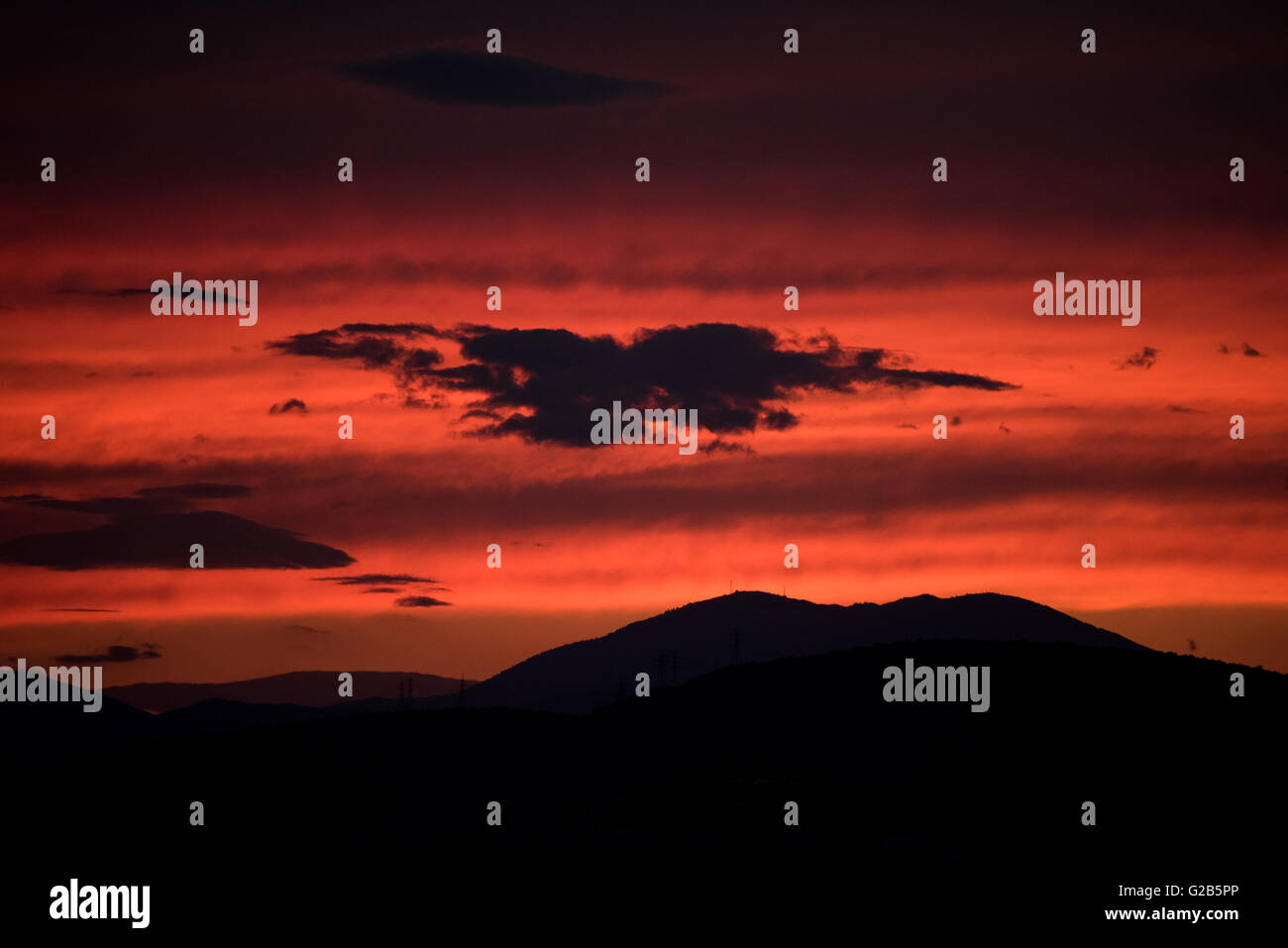Coucher de soleil sur la chaîne de montagnes Egaleo Athènes Grèce // ATHÈNES, Grèce — Un coucher de soleil rouge spectaculaire illumine la ligne d'horizon ouest d'Athènes. Le soleil se couche derrière la chaîne de montagnes Egaleo, qui forme la frontière ouest de la ville, atteignant une altitude de 468 mètres (1 535 pieds). Les silhouettes des bâtiments dans l'ouest d'Athènes et peut-être des parties du Pirée, situées à environ 12 km (7,5 miles) au sud-ouest du centre d'Athènes, sont visibles contre le ciel éclatant. Cette scène, commune à Athènes en raison de son climat méditerranéen, est intensifiée par les conditions atmosphériques et l'altitude de la ville de 70-300 mètres (230-984 fe Banque D'Images