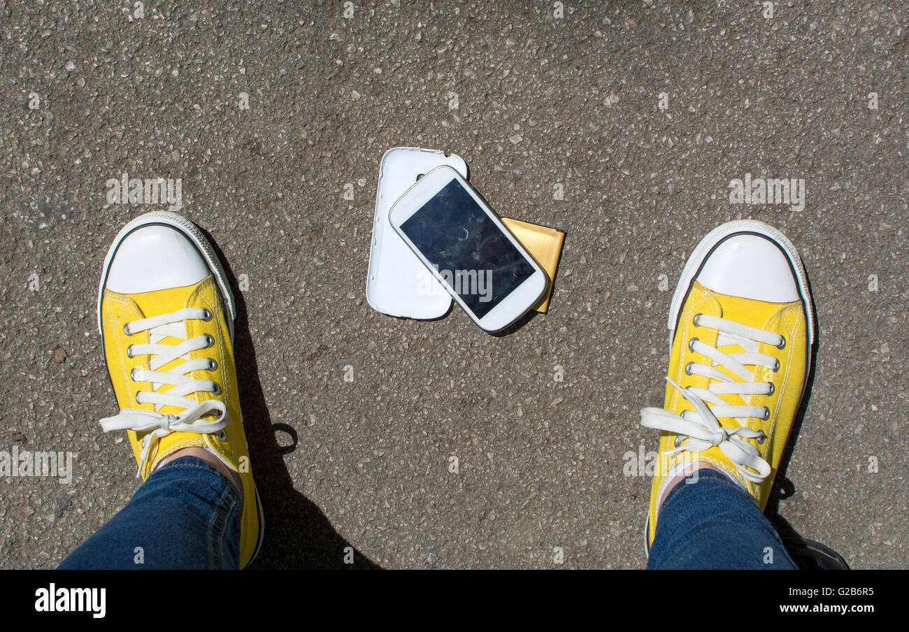 Smartphone démonté sur le sol devant personne. Point de vue à la première personne Banque D'Images
