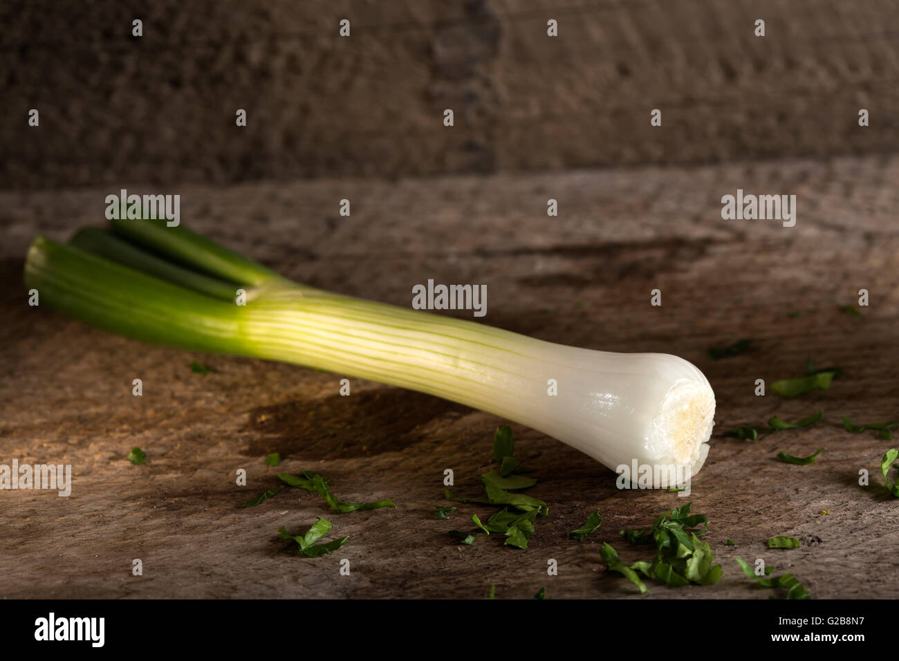 Un oignon de printemps également connu sous le nom d'oignon salade, l'oignon vert ou scallion sur fond de bois Banque D'Images