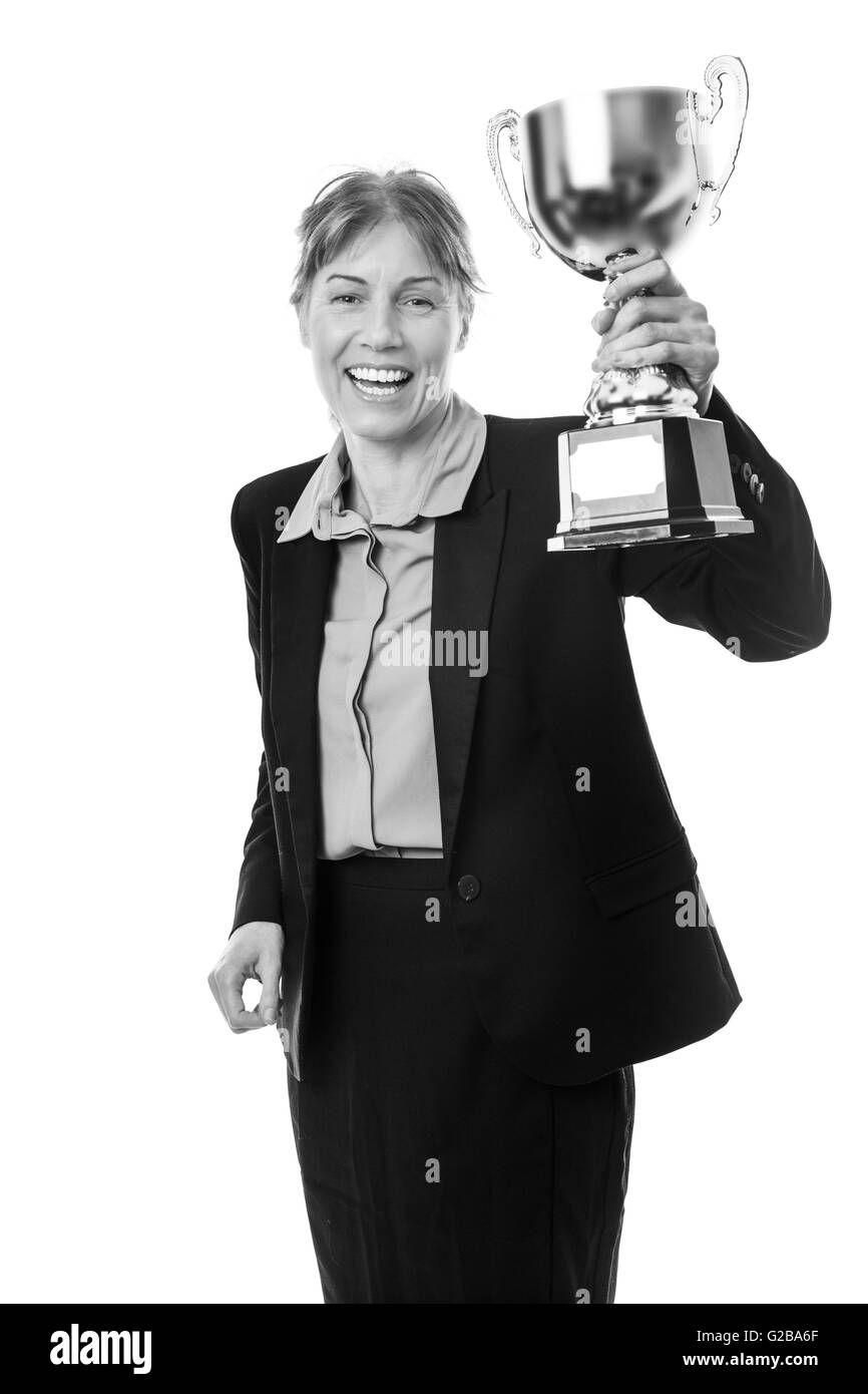 Femme d'affaires portant un costume avec une chemise bleue, serre la main sur un trophée pour célébrer sa victoire ! Banque D'Images