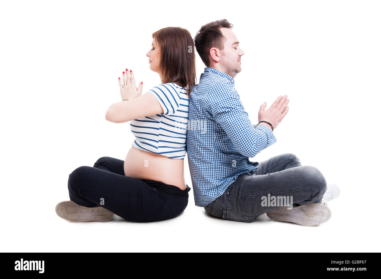 Les femmes enceintes et l'homme debout dans lotus yoga pose, relaxant et méditant isolé sur fond blanc Banque D'Images