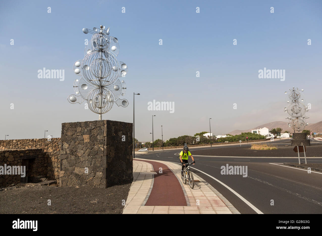 Cycliste avec Jugete de Viento jouet du vent par Cesar Manrique, Tahiche, Lanzarote, îles Canaries, Espagne Banque D'Images