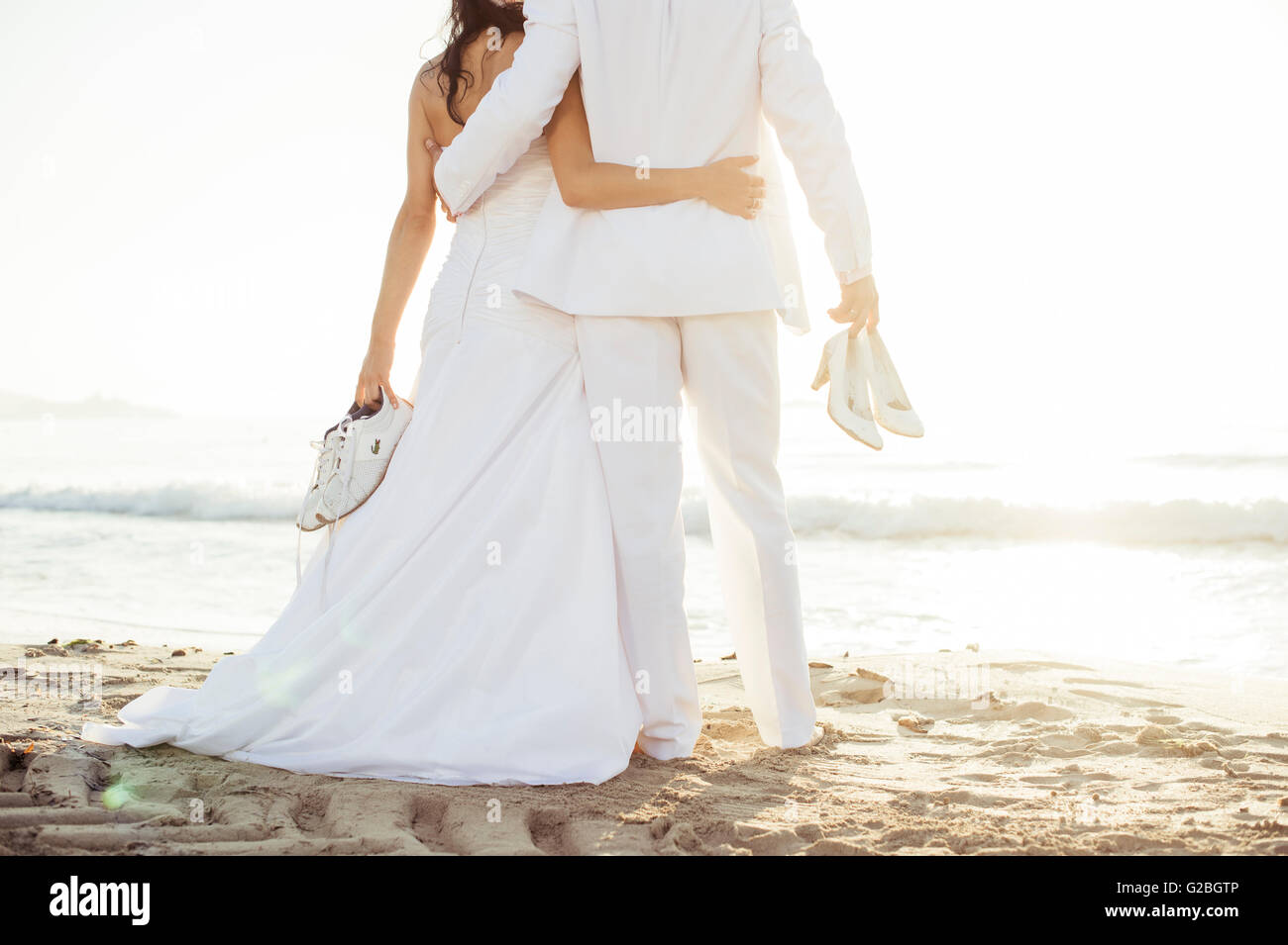 Bridal couple standing arm in arm sur la plage, Espagne Banque D'Images