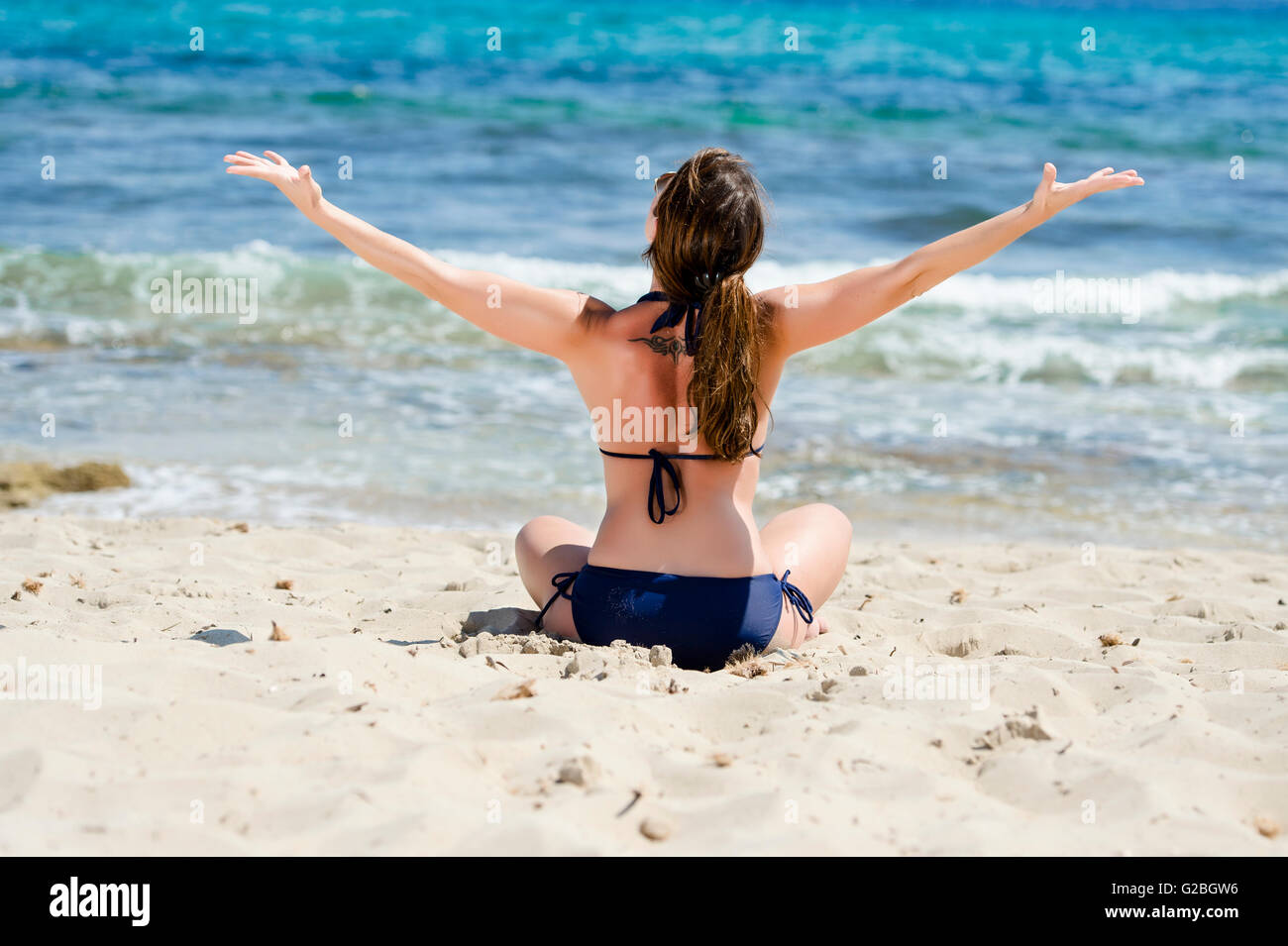 Femme assise sur la plage, Ibiza, Espagne Banque D'Images