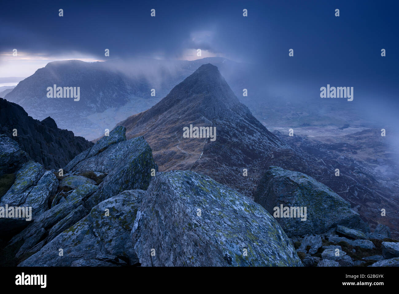 Tryfan entouré par des nuages bas au crépuscule dans les montagnes Glyder, Snowdonia. Banque D'Images