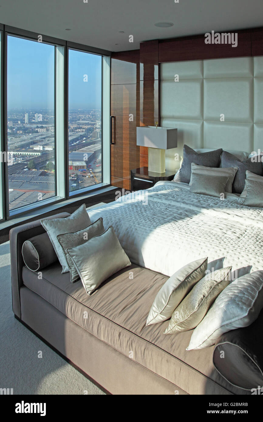 Intérieur d'un appartement au 35ème étage de la Tour, un complexe résidentiel de luxe à Vauxhall, Londres, Royaume-Uni. Montre la chambre avec des fenêtres pleine hauteur. Banque D'Images