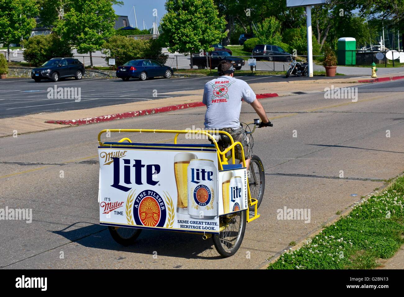 Un homme monté sur un vélo-taxi avec un Miller Lite affiche sur l'arrière du chariot Banque D'Images