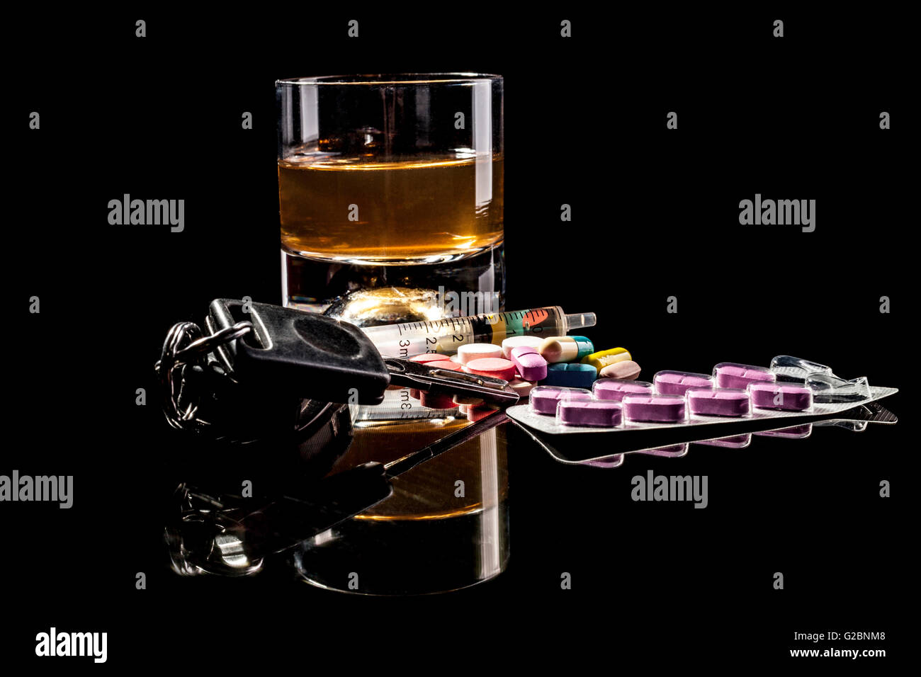L'alcool, des pilules et des clés de voiture isolé sur fond noir avec reflet Banque D'Images