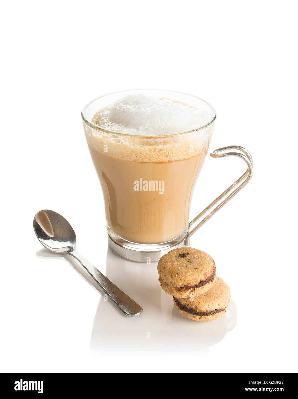 Latte Café dans une tasse en verre avec poignée, cookies et une cuillère sur un fond blanc. Banque D'Images