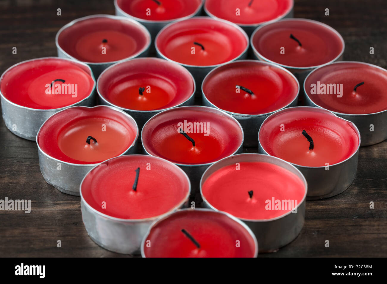 De nombreuses petites bougies rouge éteint closeup on wooden table Banque D'Images